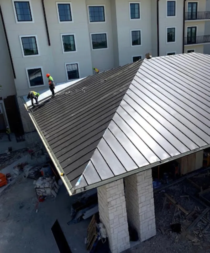Crew installing standing seam metal roof panels on a commercial project in Bayshore Gardens